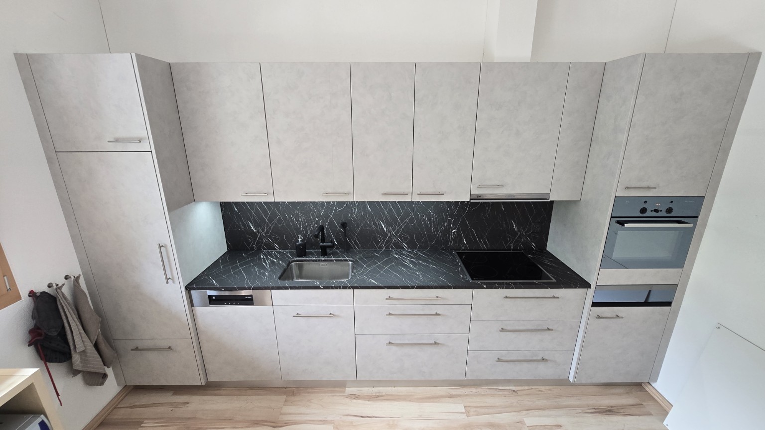 Komplett folierte Küche mit hellen Fronten und dunkler Marmoroptik in Sörenberg